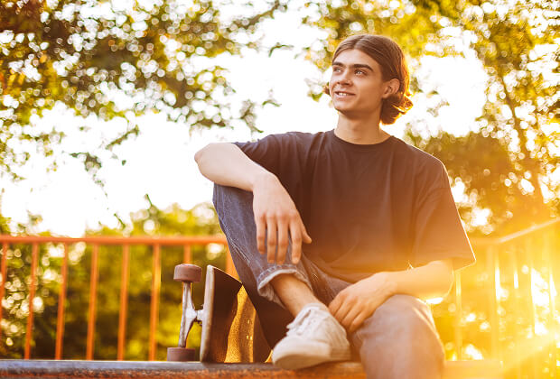 Young man relaxing on a balcony in the sunlight