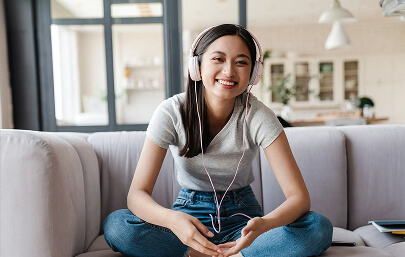 Woman with headphones on a couch talking on a video call