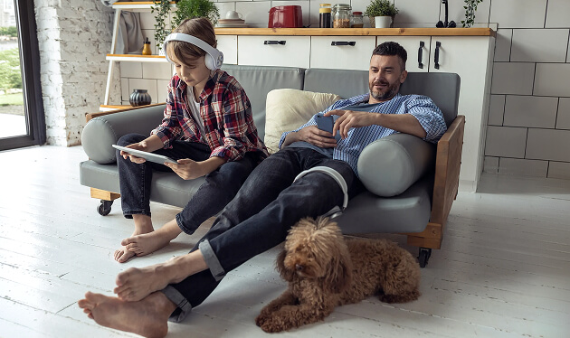 Couple relaxing at home on a sofa with their dog