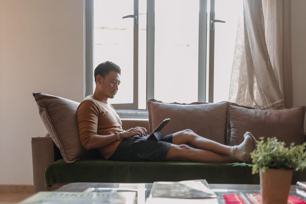 Man sitting on a sofa at home using his phone