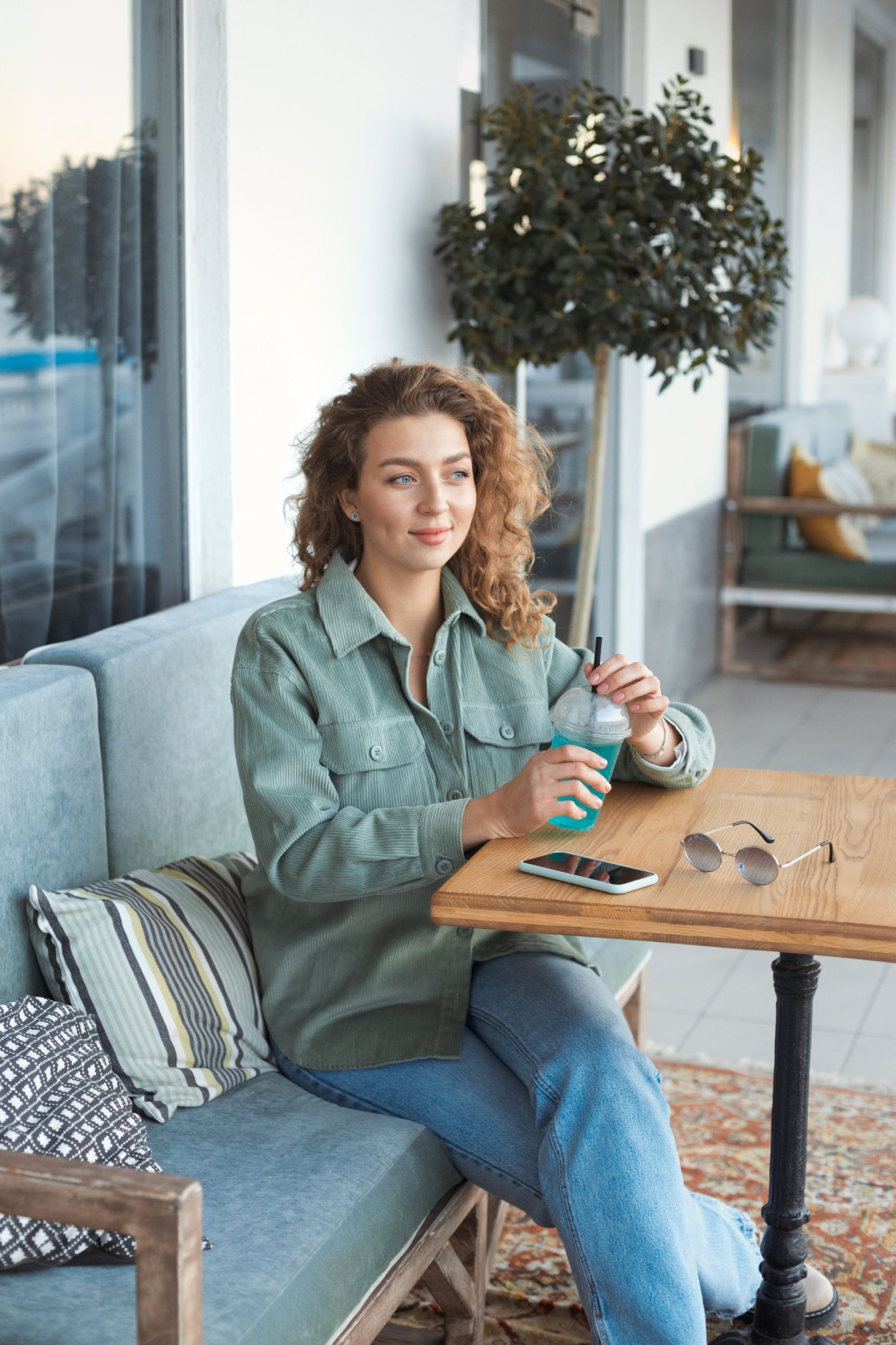 Woman with a drink sitting at a cafe table