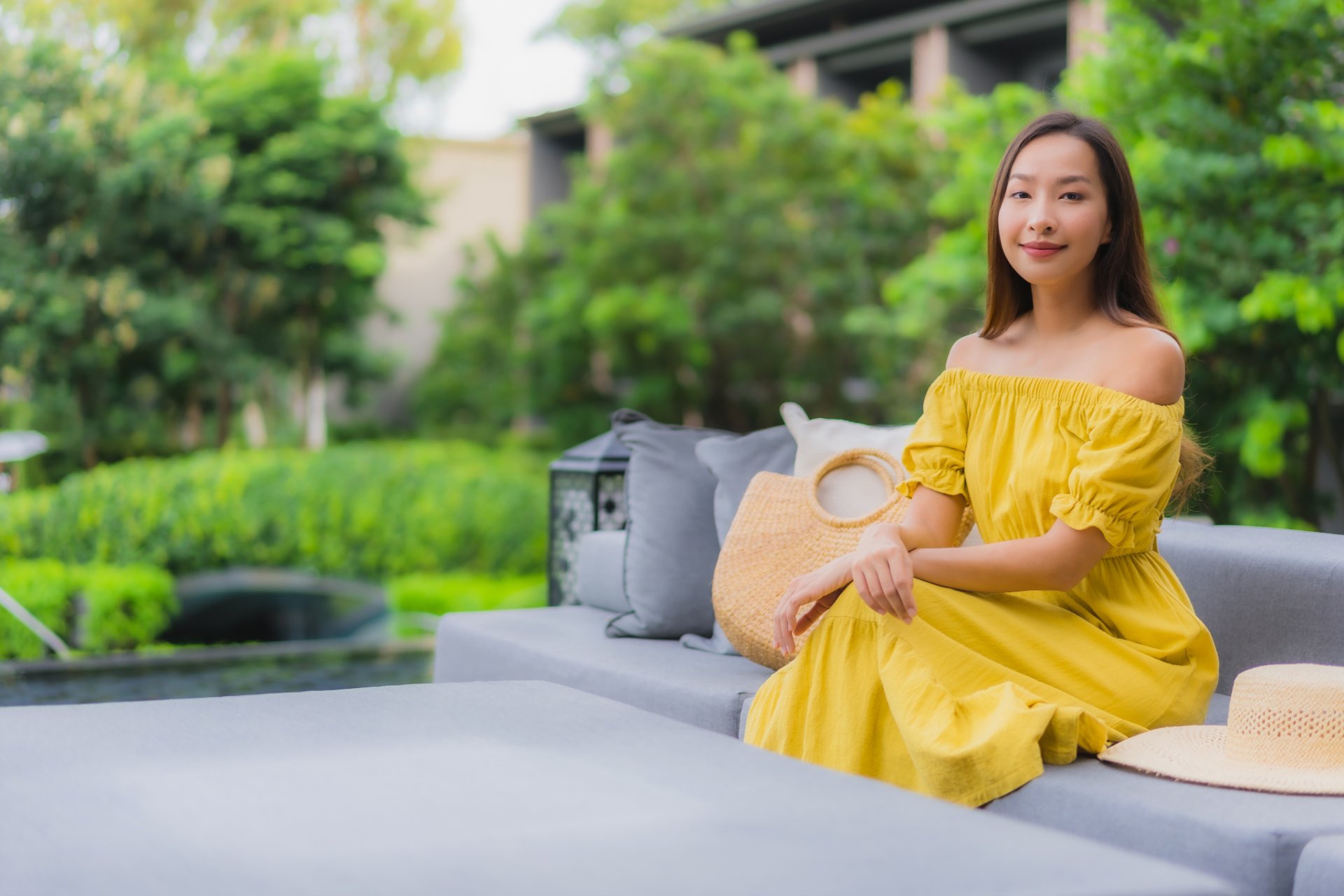 Smiling woman in a yellow dress sitting outdoors